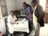 Le directeur du dispensaire, un infirmier et Dr. Kuyitila dans le dispensaire, examen du matériel donné